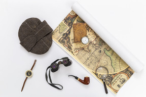 Map, cap, binoculars, smoking pipe and compass