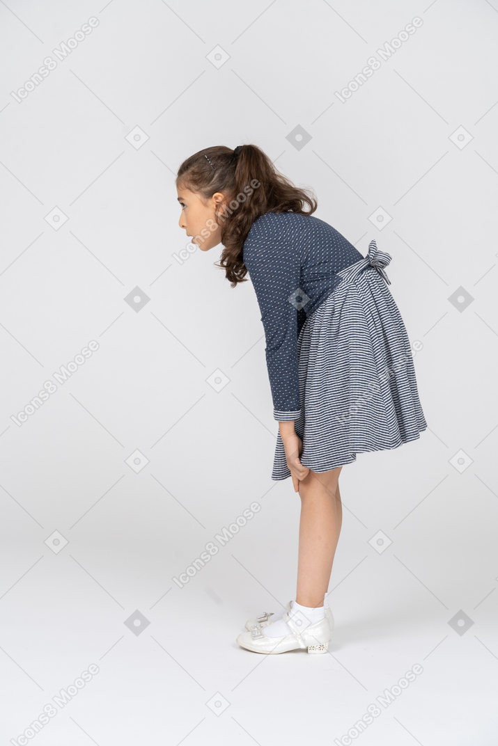 一个女孩懒散地抓住膝盖的侧视图
