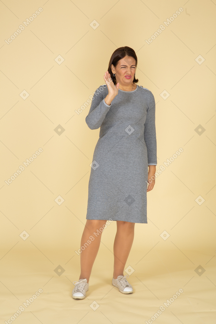 一个穿着灰色裙子摆姿势的女人的前视图