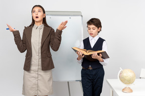 Dazed young teacher and a pupil answering in class