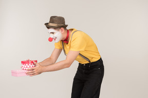 Male clown holding gift box