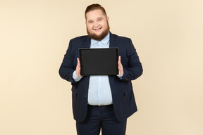 Jovem trabalhador de escritório com excesso de peso, mostrando o tablet digital