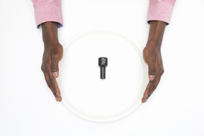 Black male hands holding white plate with nail polish on it