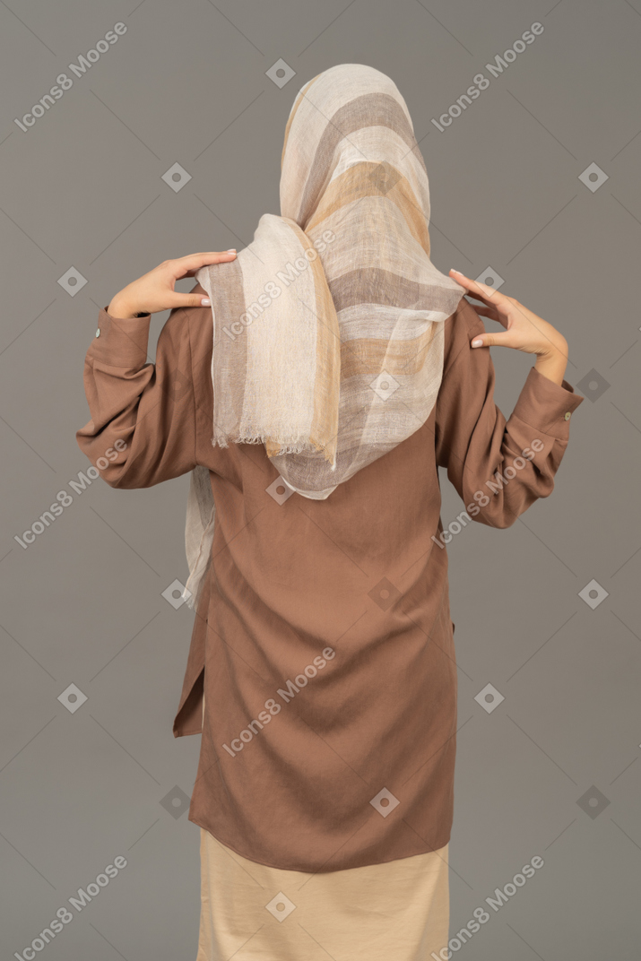 Mulher em roupas tradicionais, segurando as mãos nos ombros