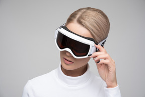 Jeune femme blonde ajustant ses lunettes de ski