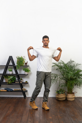 Handsome athletic man posing on the background of the apartment