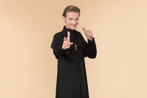 Catholic priest showing thumb up and pointing forward