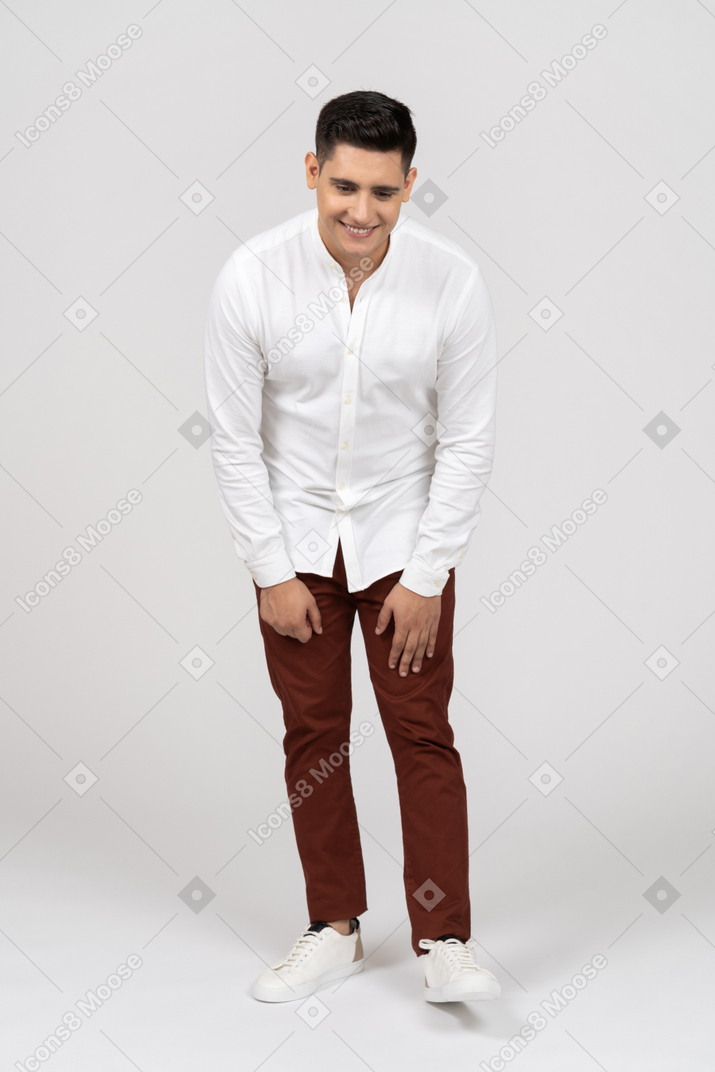 Vista frontal de um jovem latino ligeiramente inclinado para a frente e sorrindo