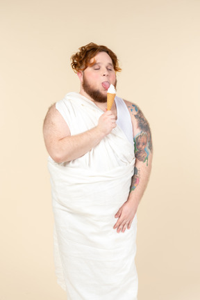 Hombre grande vestido como un cupido comiendo helado