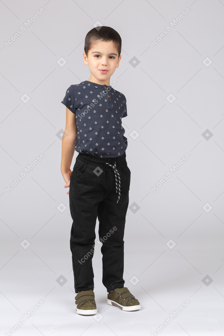 Vista frontal de um menino feliz em roupas casuais, olhando para a câmera