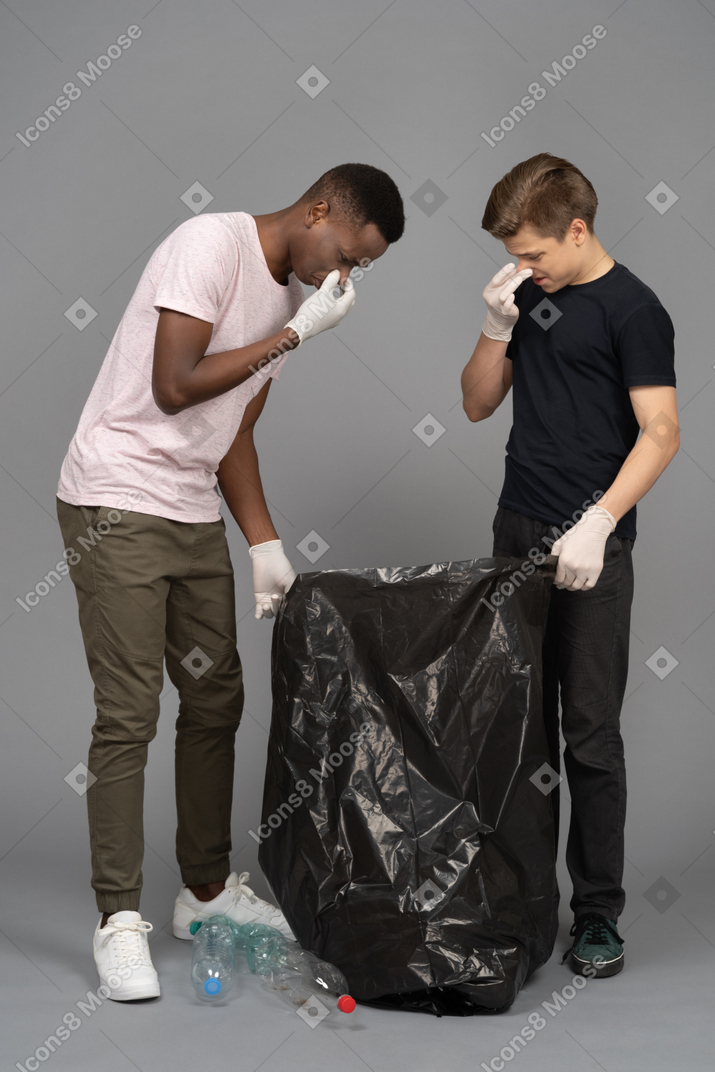 Two men closing noses because of a bad smell