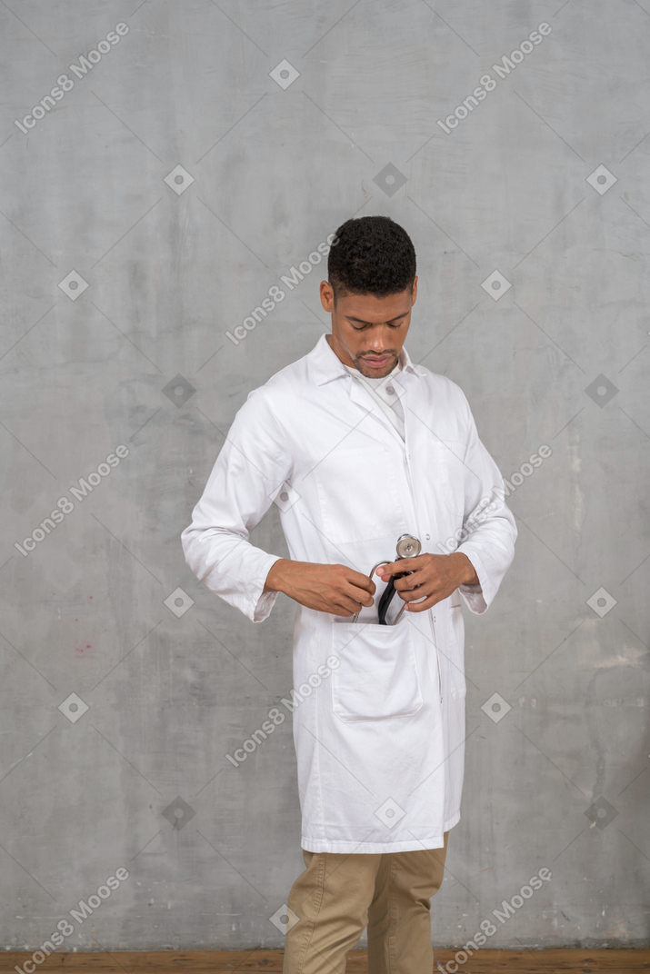 Male doctor putting his stethoscope away