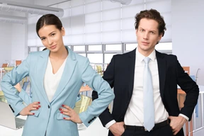 A man and a woman standing next to each other in an office