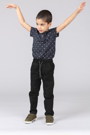 Front view of a cute boy standing with raised arms