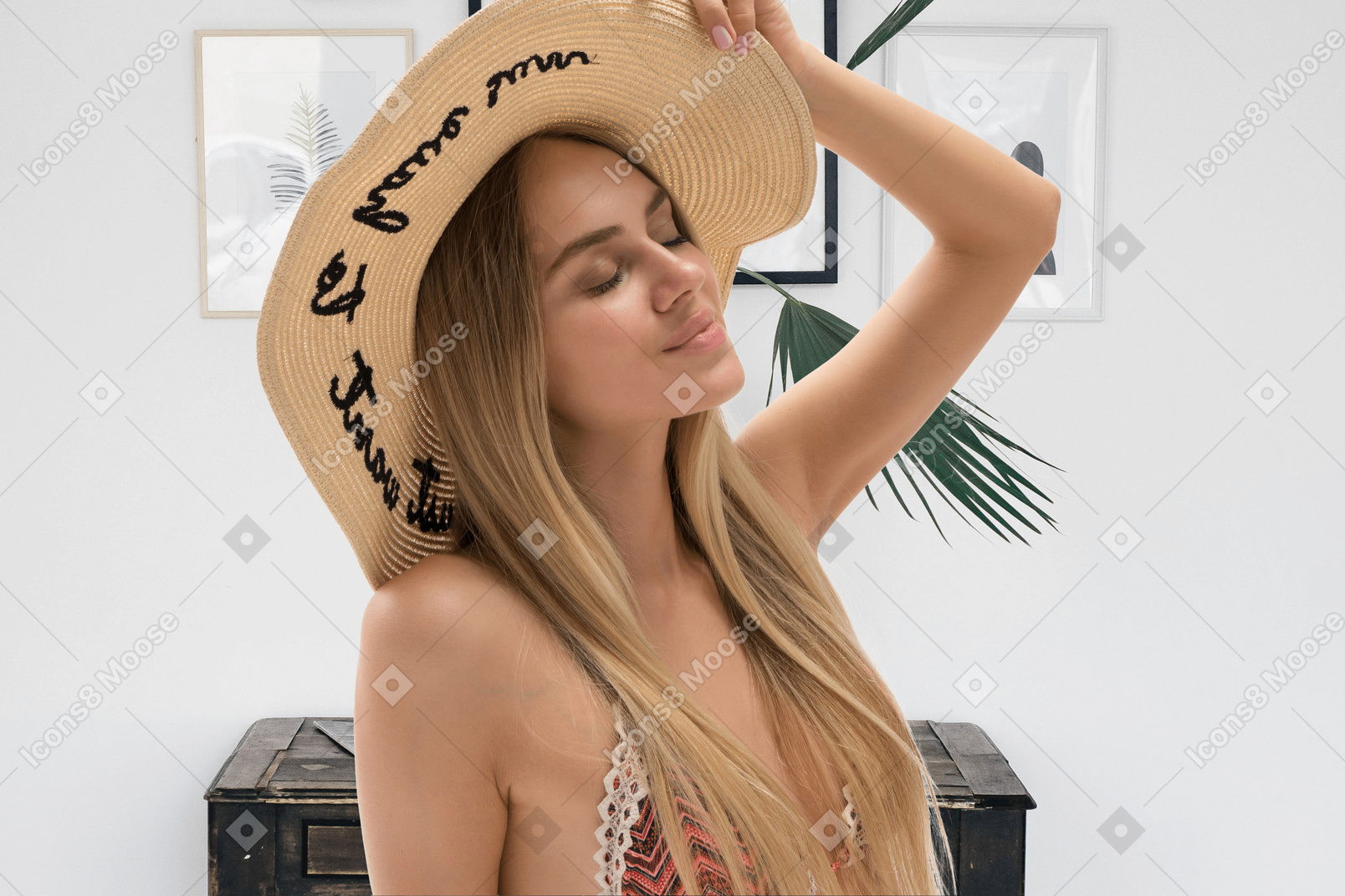A woman wearing a straw hat with writing on it
