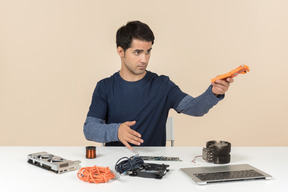 A young man in casual blue clothes working with computer details