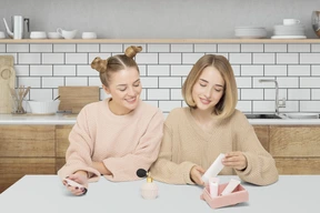 Two women sitting at a table in a kitchen