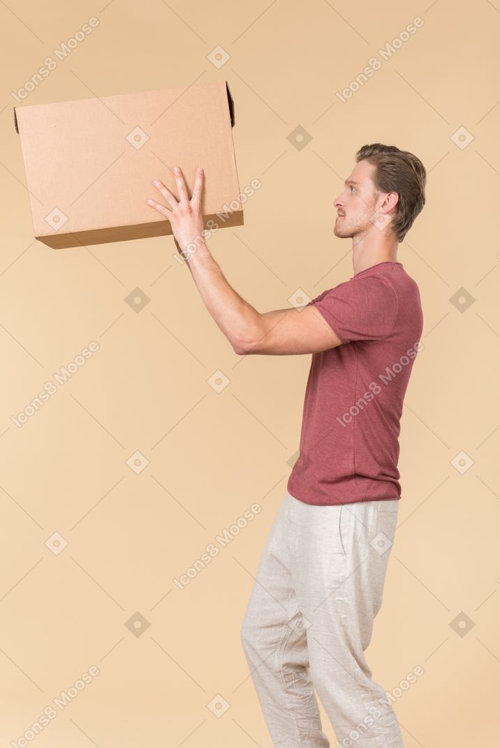 Delivery guy standing in profile and putting a parcel up