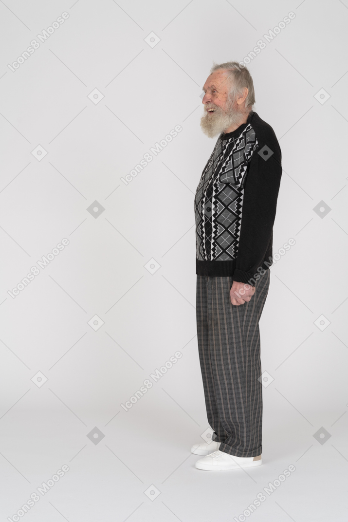 Vista lateral de un anciano de pie y riendo