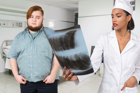 A male patient standing next to a female doctor holding x-ray