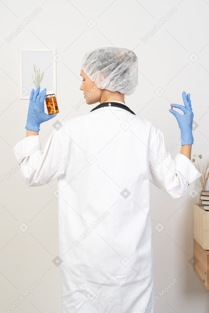 Back view of a young female doctor checking pills