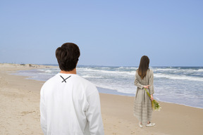 Vista traseira do casal na praia