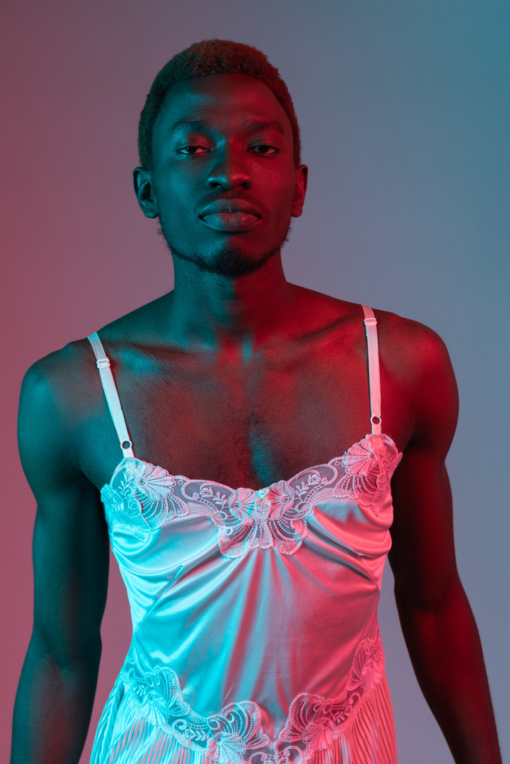 Young black man in white nightie looking at camera