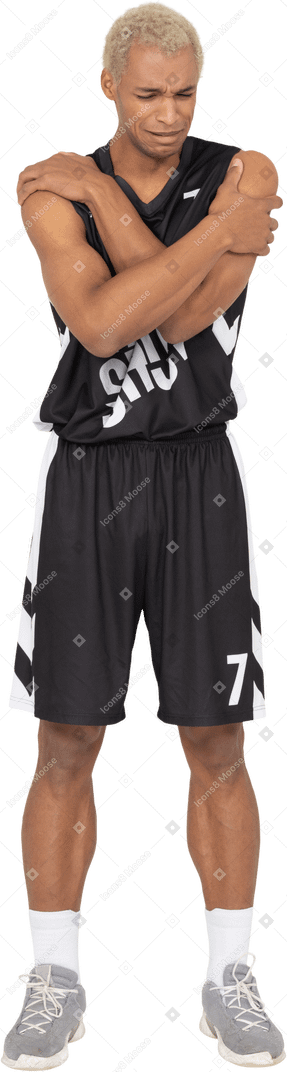 一个内向的年轻男篮球运动员拥抱自己的前视图