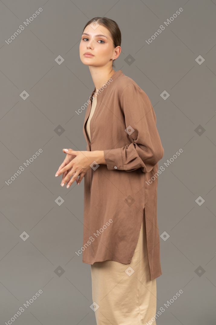 Mujer joven con manos campanario mirando a la cámara