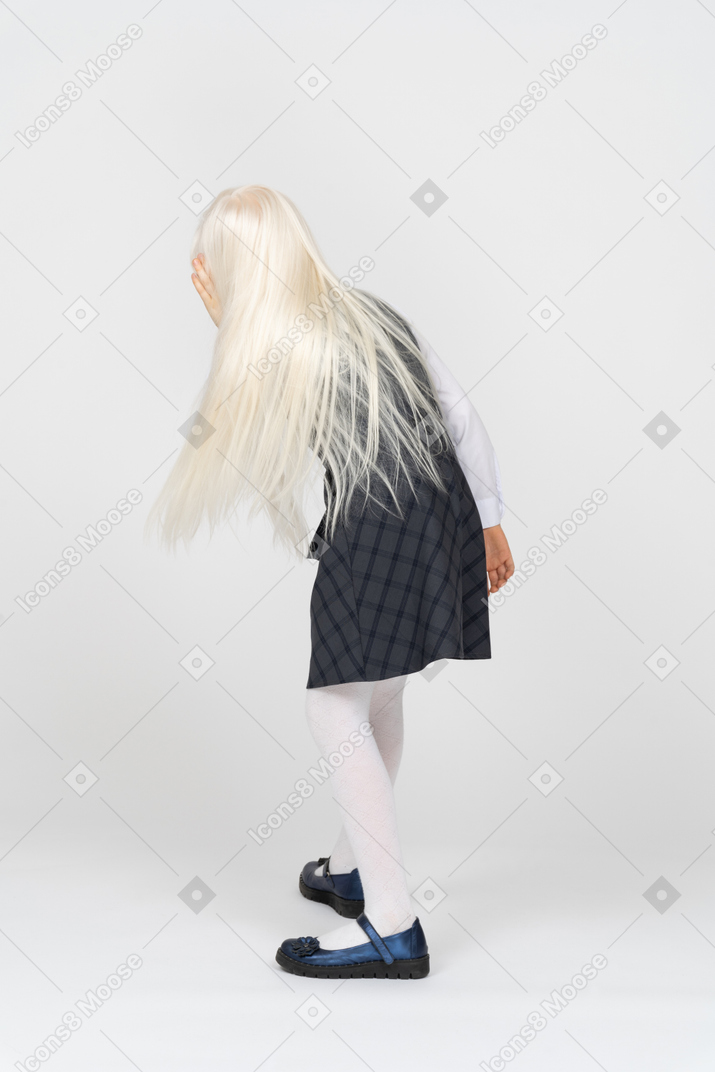 Back view of a schoolgirl leaning forward