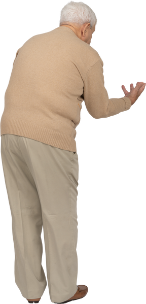 Rear view of an old man in casual clothes explaining something