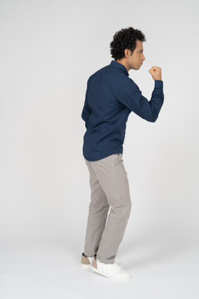 Vista lateral de um homem com roupas casuais mostrando o punho