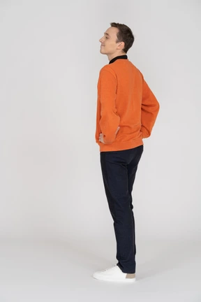 Young man in orange sweatshirt standing