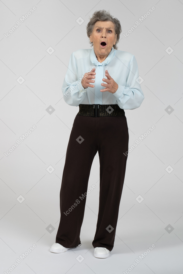 Front view of an old woman gesturing looking terrified
