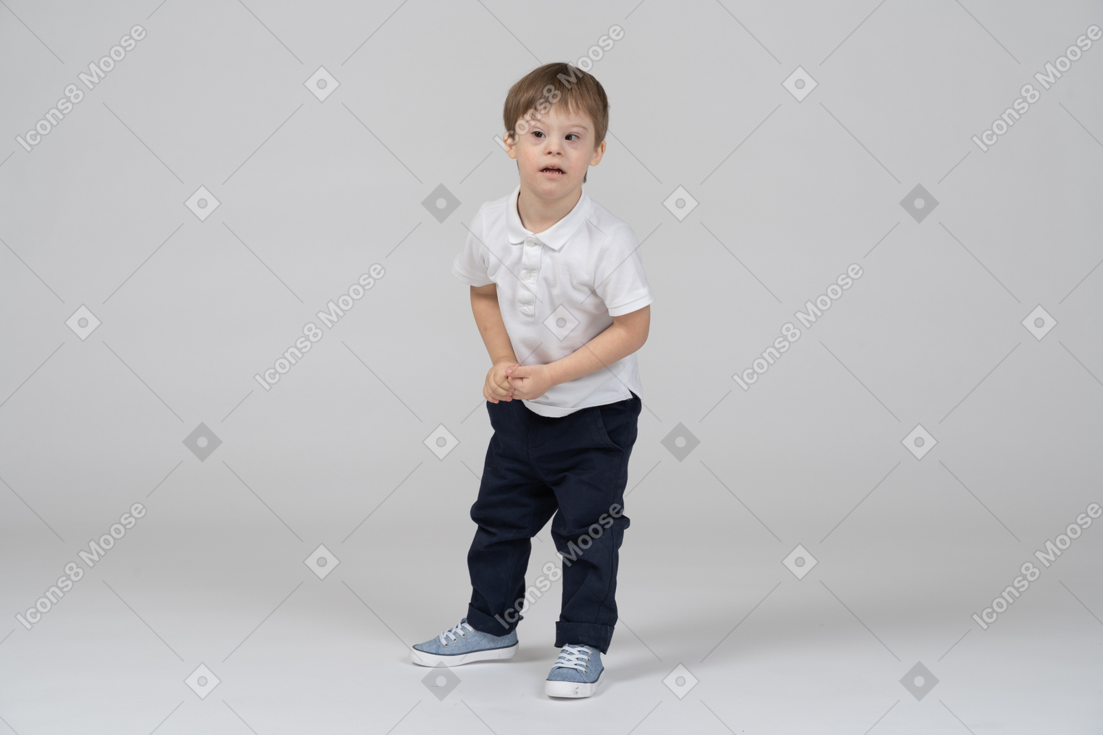 Distracted little boy standing with his hands together