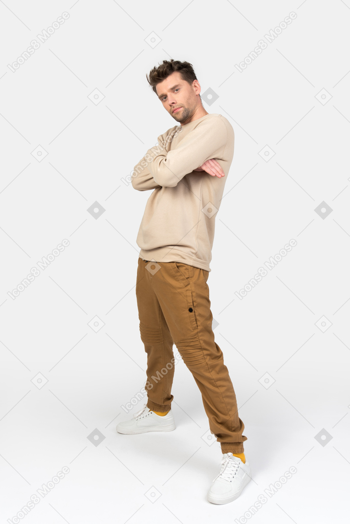 Young guy standing with his hands crossed in 'cool' position