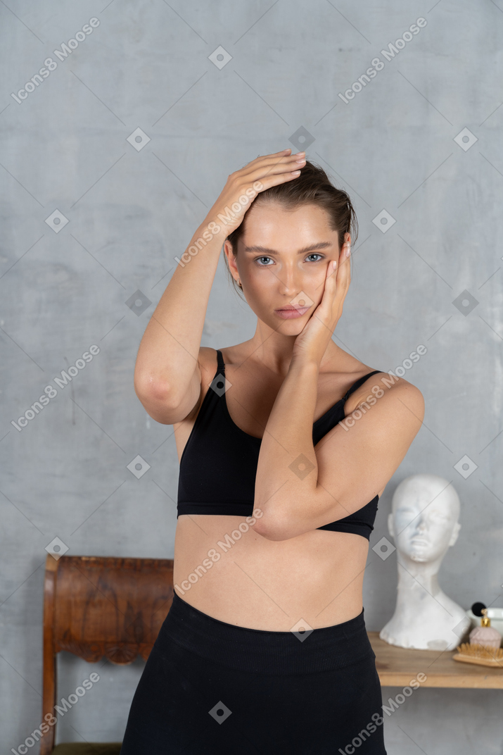 Portrait of a beautiful young woman holding head with both hands