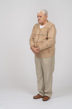 じっと立っているカジュアルな服を着た悲しい老人の正面図