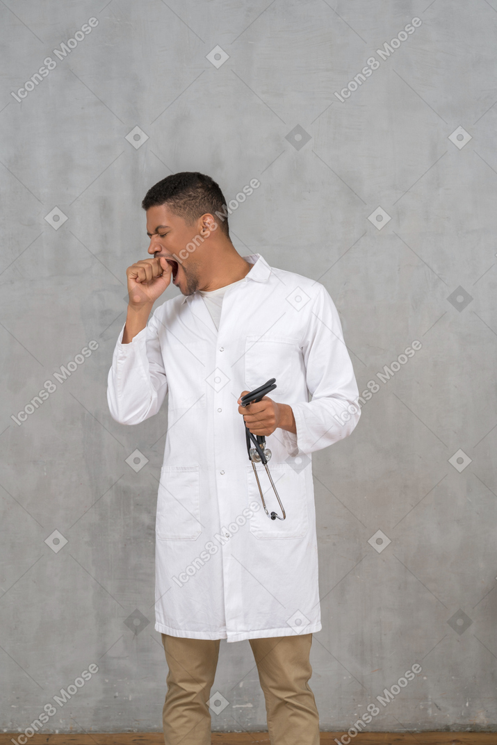 Male doctor yawning