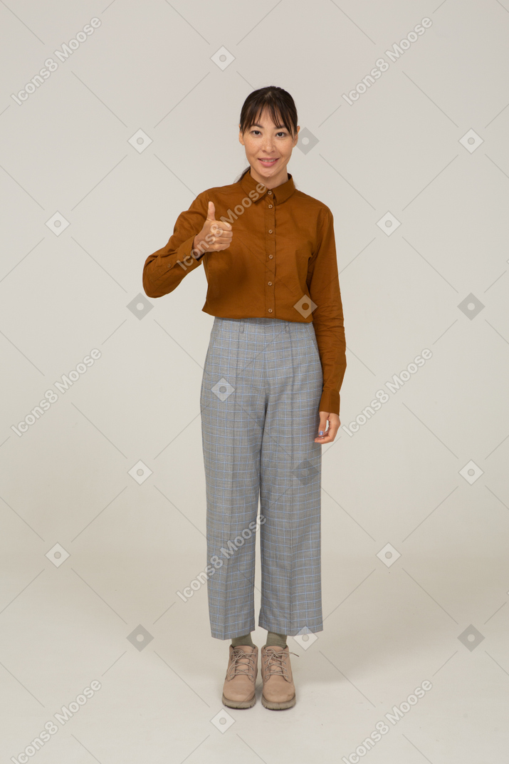 一位身着马裤和衬衫的年轻亚洲女性的前视图，她竖起大拇指