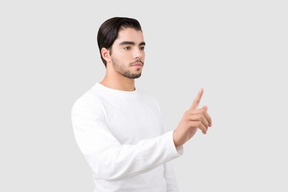 Attraktiver junger mann, der mit einem finger zeigt