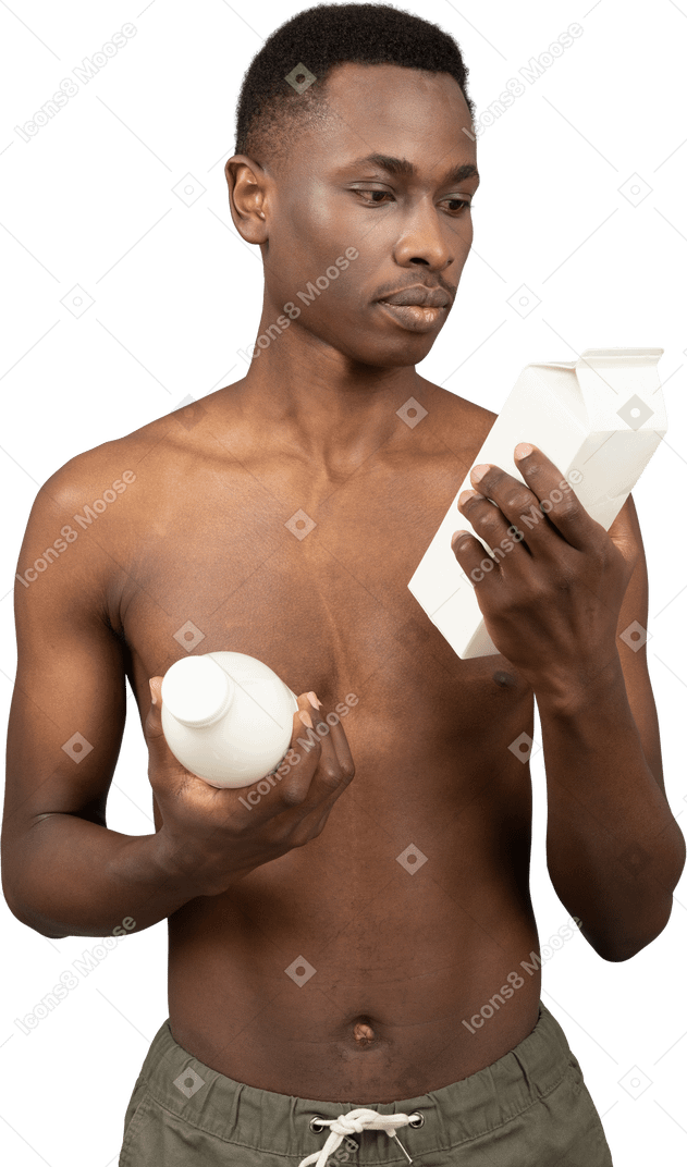 A shirtless young man holding milk