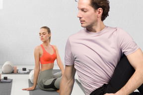 A man and a woman doing yoga in a room