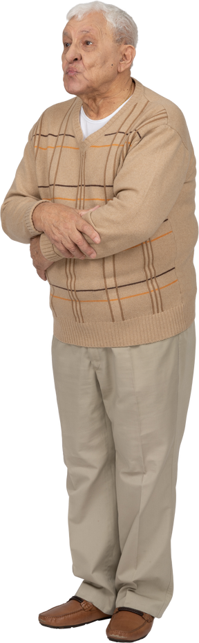 Вид спереди на старика в повседневной одежде, стоящего со скрещенными руками и смотрящего в камеру
