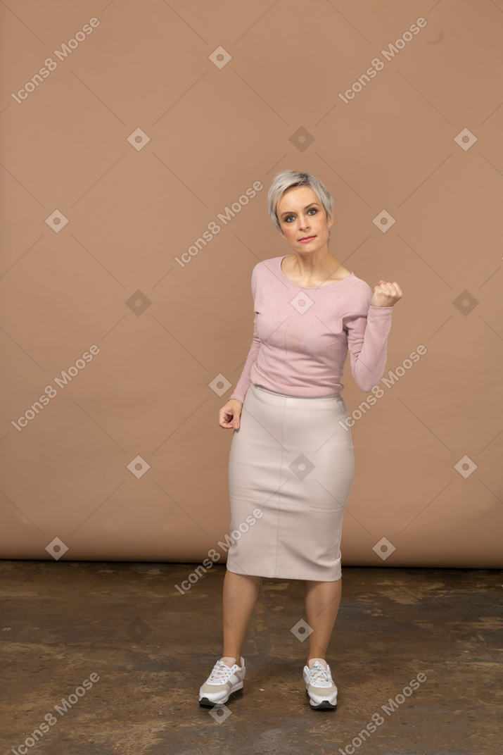 一个穿着休闲服的愤怒女人展示拳头的前视图