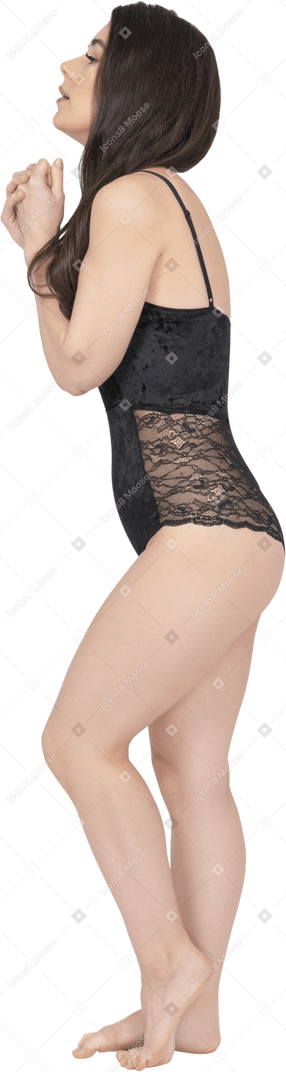 Caucasian woman in black bodysuit posing in profile