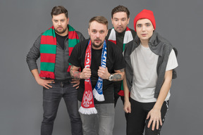 Close-up of four male football fans looking straight