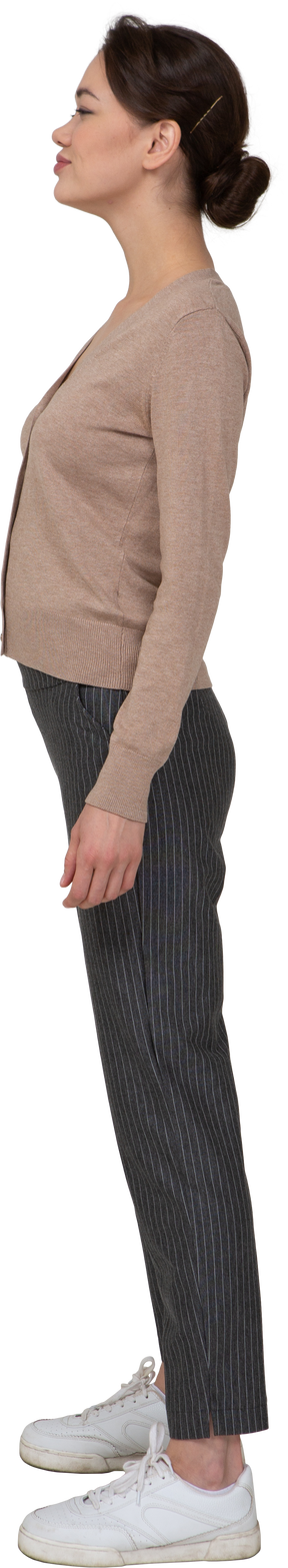 Vista lateral de uma jovem suspeita de blusa e calças