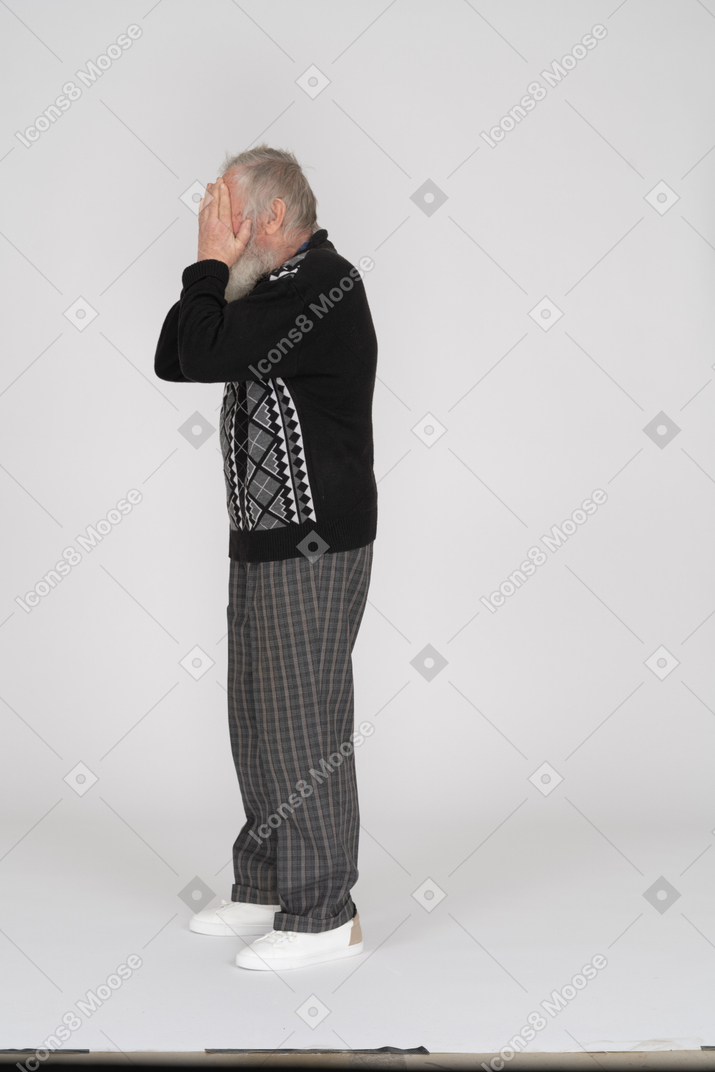 Uomo anziano che si copre il viso con le mani
