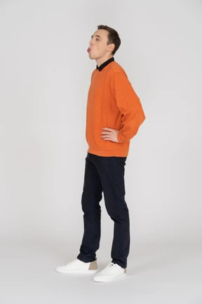 Man standing with hands on hips showing his tongue